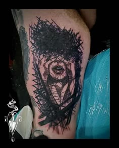 a man's arm with a black and grey tattoo design on the left thigh