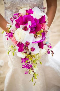 a bride holding a purple and white bouquet