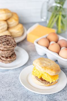 an egg sandwich on a plate next to other breakfast foods