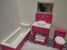 a pink and white bathroom with a tub, sink, toilet and mirror