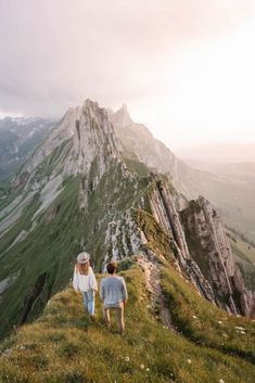 two people walking up the side of a mountain