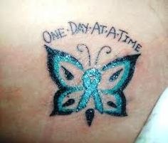 a blue butterfly with the words one day at a time on it's back