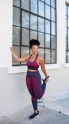 a woman is posing in front of a window with her leg up and one hand on her hip