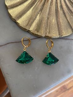 Vintage emerald green glass stone set in a raw brass setting measuring 1.8 cm x 1.3 cm. Hung on gold-plated huggie hoop earrings measuring 1.2 cm x 1.4 cm. Comes in a black velvet pouch. If these are a gift and you would like a box free of charge please mark the order as gift or leave a message at check out. Green Tarnish-resistant Huggie Jewelry, Green Small Hoop Earrings Tarnish Resistant, Green Nickel-free Huggie Earrings, Small Hoop Green Earrings Tarnish Resistant, Green Gold-plated Tarnish-resistant Hoop Earrings, Green Tarnish Resistant Hoop Earrings For Gift, Small Hoop Green Tarnish-resistant Earrings, Green Tarnish-resistant Gold-plated Hoop Earrings, Green Tarnish Resistant Small Hoop Earrings