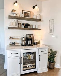 a kitchen with white cabinets and shelves filled with coffee items on top of the counter