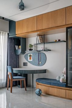 a living room filled with furniture next to a wall mounted shelf above a desk and chair