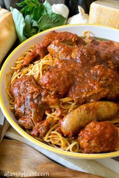 a bowl filled with spaghetti and meat covered in sauce