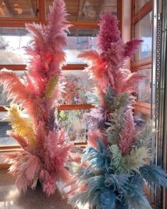 two vases filled with colorful flowers next to a window