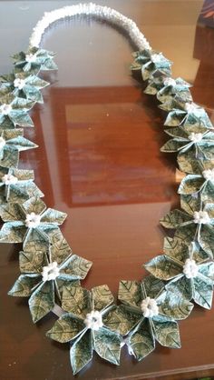 a necklace made out of dollar bills sitting on top of a table