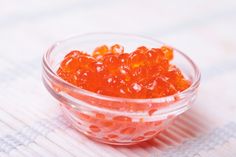 a bowl filled with orange gummy bears sitting on top of a white tablecloth