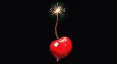 a red heart shaped object with a sparkler on it