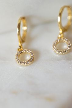 Our Myla Dainty O-Ring Huggie Earrings are the perfect minimalist earrings! Made with a crystal beaded gold filled O-Ring attached to a gold filled huggie hoop. These simple earrings are a beautiful staple piece! Everyday Gold Cubic Zirconia Earrings, Gold Dainty Hoop Earrings With Sparkling Stones, Dainty Gold Hoop Earrings With Sparkling Stones, Gold Cubic Zirconia Hoop Earrings With Halo, Gold Plated Hoop Earrings With Sparkling Stones, Gold Plated Earrings With Sparkling Stones, Gold Halo Earrings Perfect As A Gift, Gold Halo Earrings For Gift, Gold Halo Earrings Perfect For Gifts