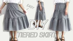 a woman wearing a white shirt and grey skirt with the words diy tiered skirt