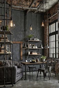 an industrial style living room with grey walls and exposed ceiling, black iron pipe shelving, gray couches, wooden shelves, hanging lights and potted plants