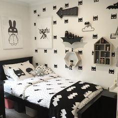 a bed room with a neatly made bed and lots of decorations on the wall above it