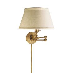 an antique brass swing arm lamp with a white shade on the top and bottom part