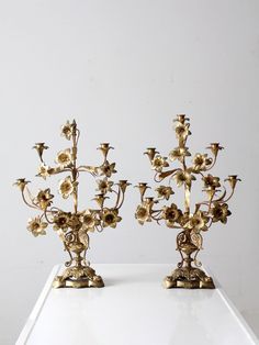 two golden candlesticks with flowers on them