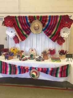 a table topped with lots of food and decorations on top of a white table cloth