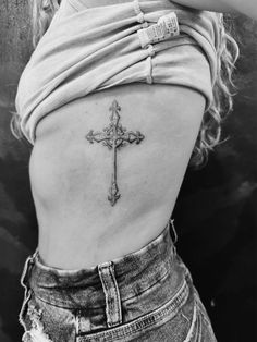 a woman with a cross tattoo on her back