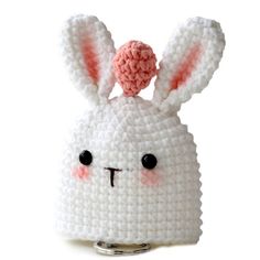 a crocheted white bunny purse with pink nose and ears on it's head