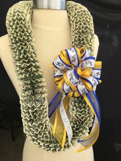 a mannequin wearing a yellow, white and blue ribbon with letters on it