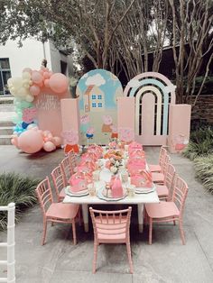 a table set up with pink chairs and balloons in the shape of castles, castles and buildings