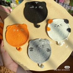 three crocheted cats sitting on top of a plate