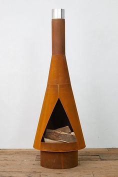 a wood burning stove sitting on top of a wooden floor next to a white wall