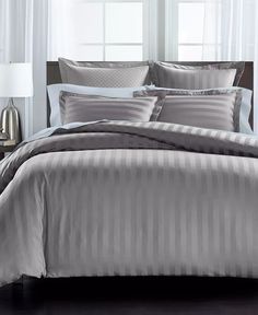 a bed with grey and white striped comforter