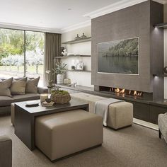 a living room filled with furniture and a flat screen tv mounted to the wall next to a fire place