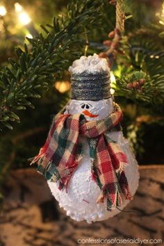 a snowman ornament hanging from a christmas tree