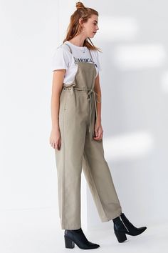 Details Workwear-inspired apron look overall that majorly upgrades your utilitarian game. Made from a lightweight linen-blend fabrication in a sleeveless, relaxed-fit silhouette that features a tie at the waist + silver grommet detailing. Features an open back with cross-strap detailing. Finished with a straight-leg pant bottom, side-entry pockets + pockets at the back. Content + Care- Linen, rayon- Machine wash- Imported color : Taupe(tan-beige) Size + Fit- Model is 5'10" and wearing size Small Waist Apron, Fashion Baby, Cross Straps, Straight Leg Pants, And Sign, Latest Styles, Linen Blend, Open Back, Apron