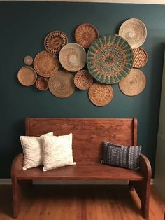 a wooden bench sitting in front of a wall with baskets on it