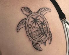 a woman's back with a turtle and palm trees on it