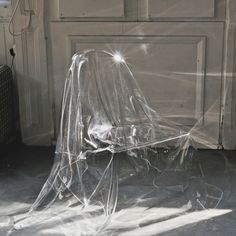 a chair covered with plastic sitting in front of a door