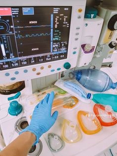 a person in blue gloves is looking at an electronic screen with medical equipment on it