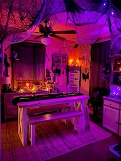 a kitchen with purple lighting and decorations on the ceiling, along with a wooden table