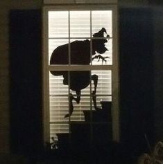 the silhouette of a cow is seen through an open window