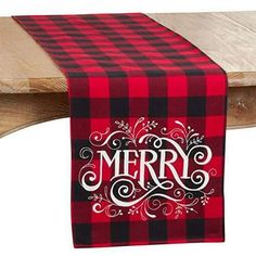 a red and black plaid table runner with merry written on it