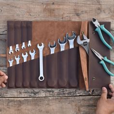 there are many different tools on the table and one person is holding it in their hand