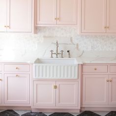 a kitchen with pink cabinets and a white sink