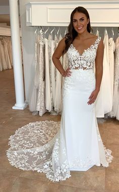 a woman standing in front of some wedding dresses