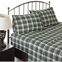 a bed with a plaid comforter and two night stands