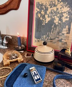 a blue bag sitting on top of a counter next to a painting and other items