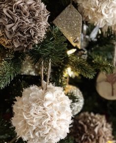 a close up of a christmas tree with ornaments hanging from it's branches and decorations