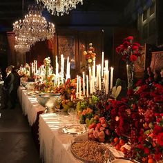 a long table covered in lots of flowers and candles