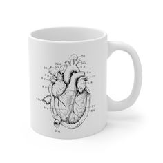 a white coffee mug with a diagram of the human heart on it's side