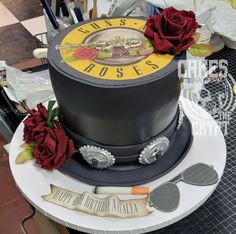 there is a cake with roses on it and other items around the cake that are sitting on a table