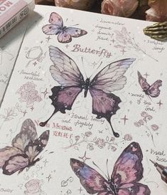 some butterflies are on top of a white paper with pink flowers in front of it