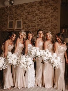 a group of women standing next to each other holding bouquets